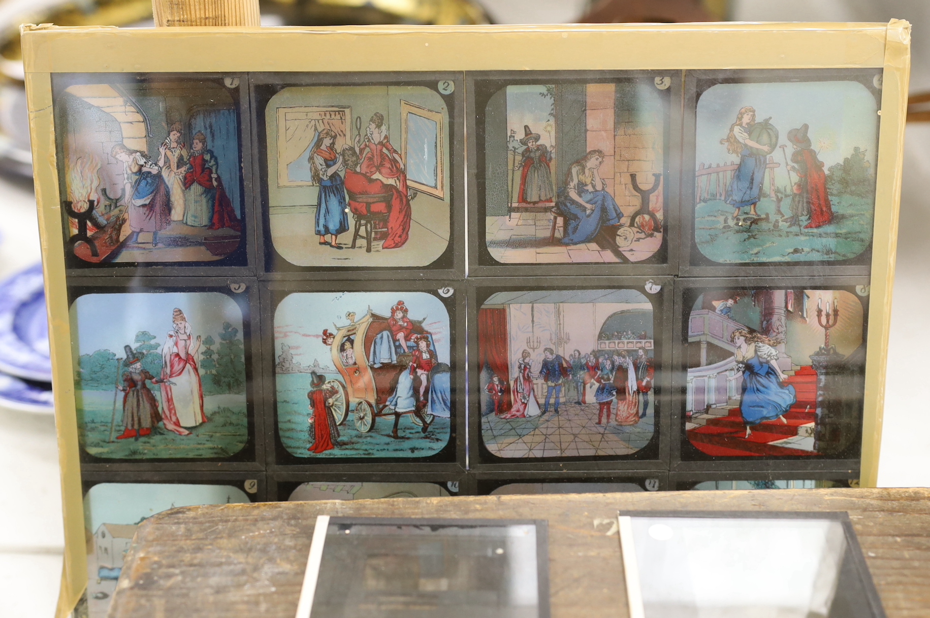 A magic lantern and three wooden boxes of slides and a panel of coloured slides